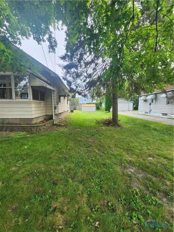 view of yard featuring a garage and an outdoor structure