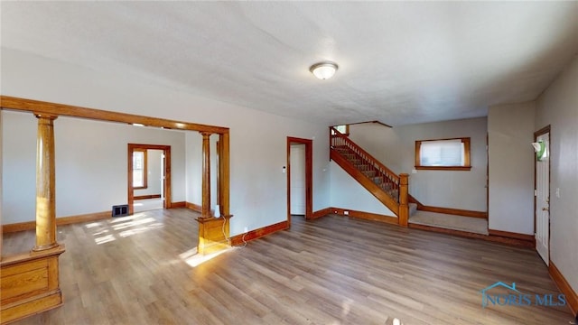 spare room featuring wood-type flooring and ornate columns