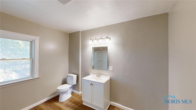 bathroom featuring vanity, wood-type flooring, and toilet