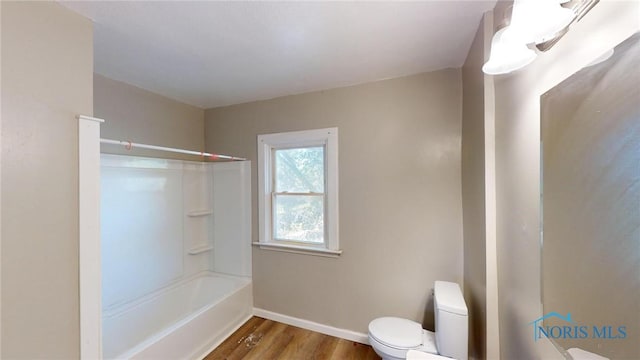 bathroom featuring hardwood / wood-style floors, bathtub / shower combination, and toilet