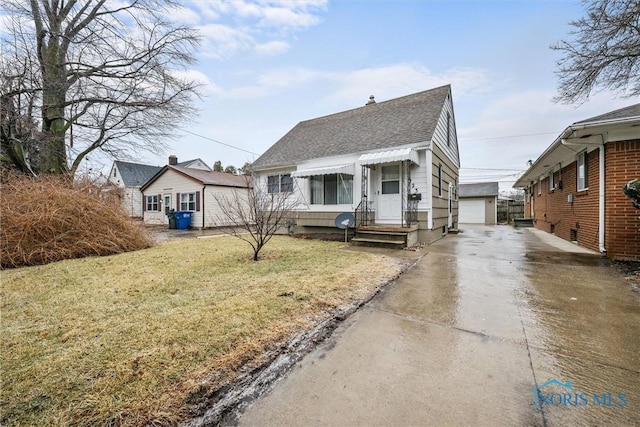 bungalow-style home with a garage and a front lawn