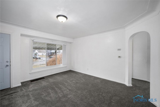 unfurnished room featuring dark carpet