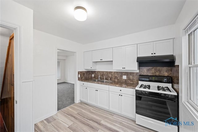 kitchen with white cabinetry, sink, decorative backsplash, light hardwood / wood-style floors, and gas range