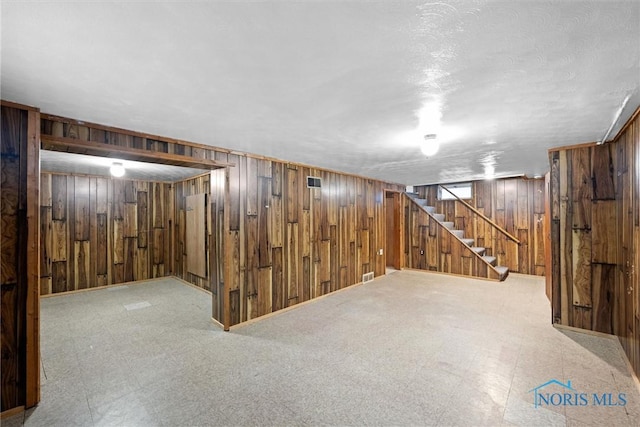 basement featuring wooden walls