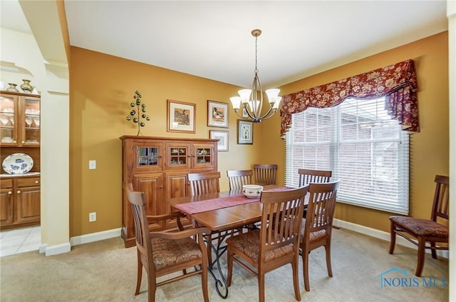 dining room featuring light carpet and a chandelier