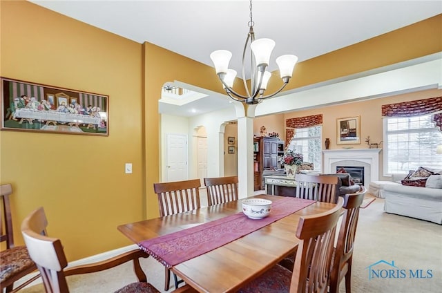 carpeted dining space with an inviting chandelier