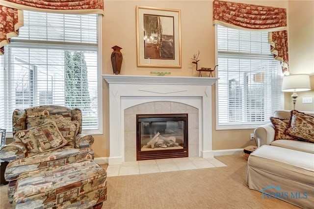 sitting room with light colored carpet and a tiled fireplace