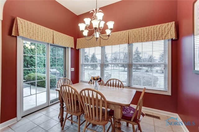 tiled dining room with a notable chandelier