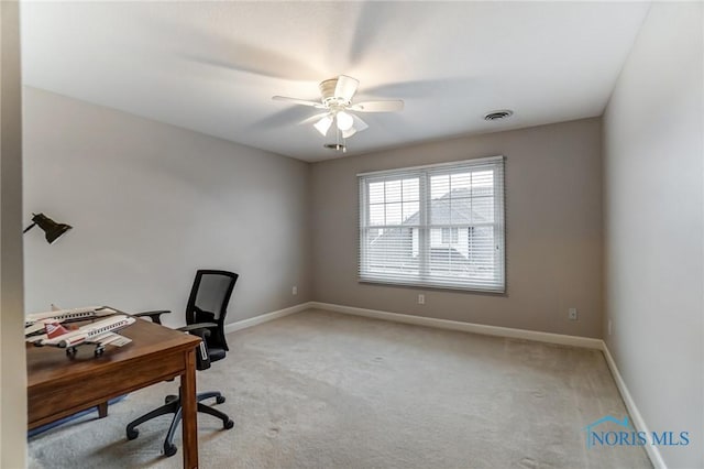 carpeted home office featuring ceiling fan