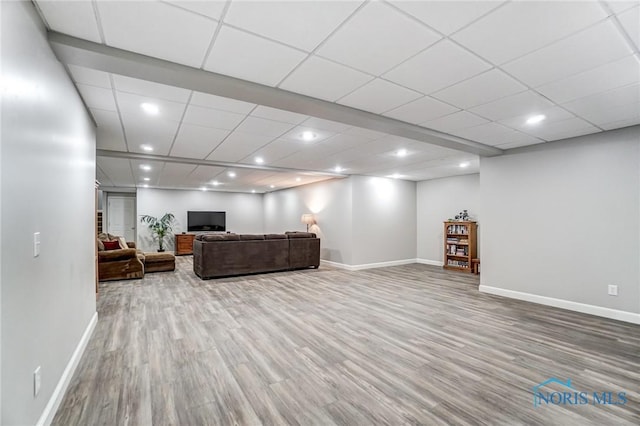 living room with hardwood / wood-style flooring and a paneled ceiling