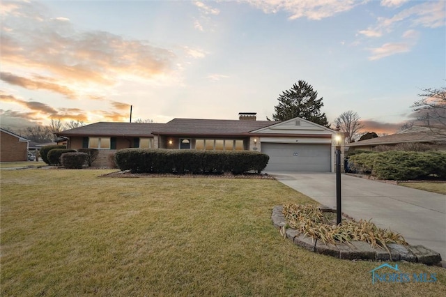 view of front of property with a garage, concrete driveway, a chimney, and a front lawn