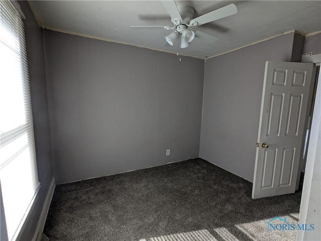 carpeted spare room featuring ceiling fan