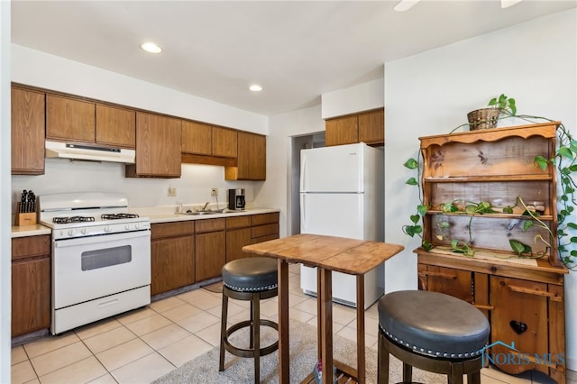 kitchen featuring sink, white appliances, and light tile patterned floors