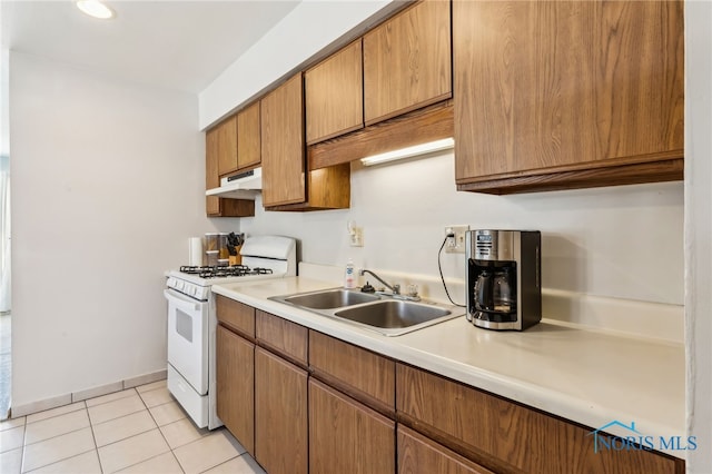 kitchen with sink, light tile patterned floors, and white range with gas stovetop