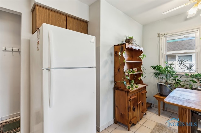 kitchen featuring light tile patterned floors, ceiling fan, and white fridge