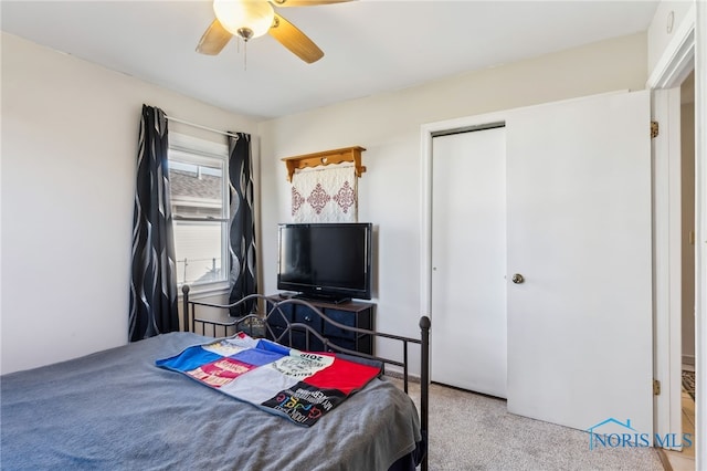 carpeted bedroom featuring ceiling fan and a closet