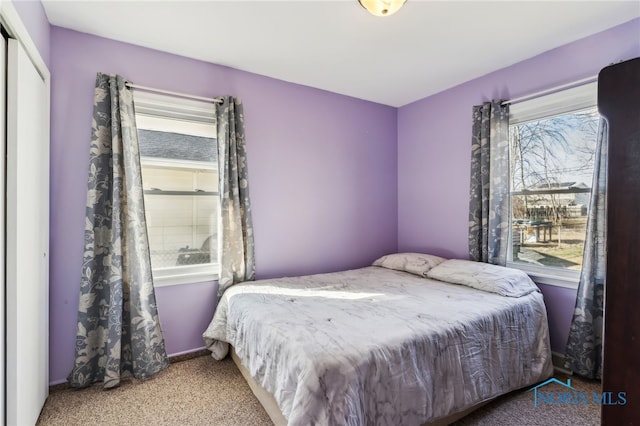 carpeted bedroom featuring multiple windows