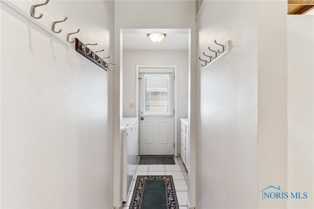 doorway to outside featuring washer and dryer and light tile patterned floors