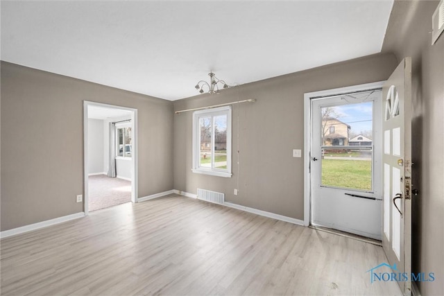 interior space featuring an inviting chandelier and light hardwood / wood-style flooring