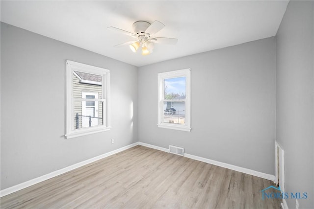 empty room with ceiling fan and light hardwood / wood-style floors