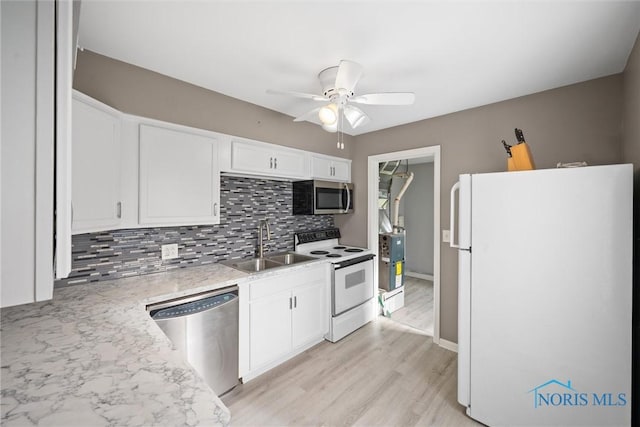 kitchen with tasteful backsplash, sink, white cabinets, and appliances with stainless steel finishes