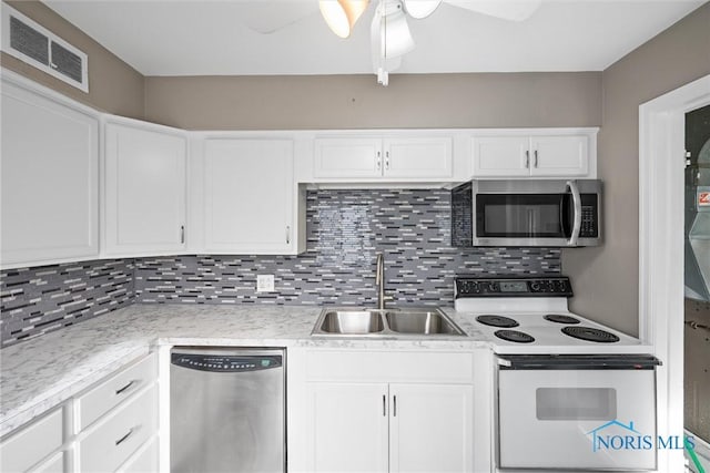 kitchen with stainless steel appliances, sink, decorative backsplash, and white cabinets