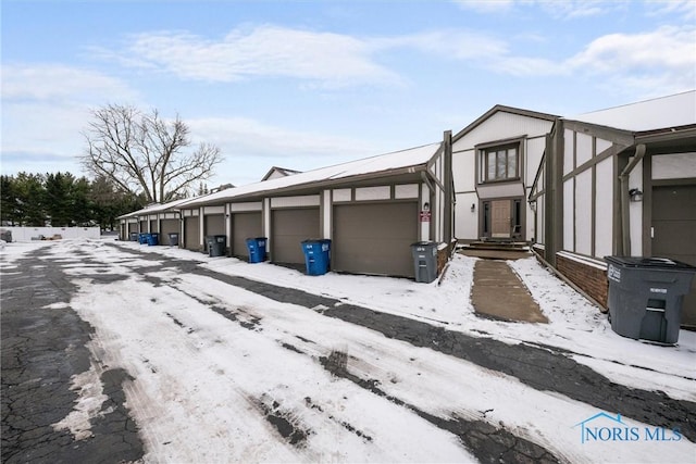 view of snowy exterior featuring a garage