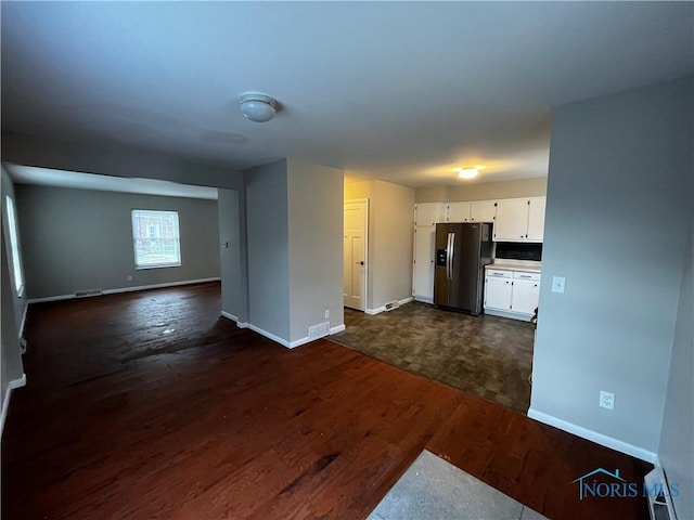 kitchen featuring white cabinetry, stainless steel fridge, and dark hardwood / wood-style floors