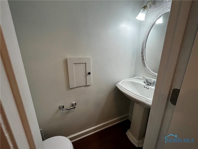 bathroom featuring hardwood / wood-style flooring and toilet