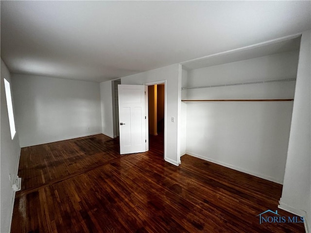 unfurnished bedroom with dark hardwood / wood-style flooring