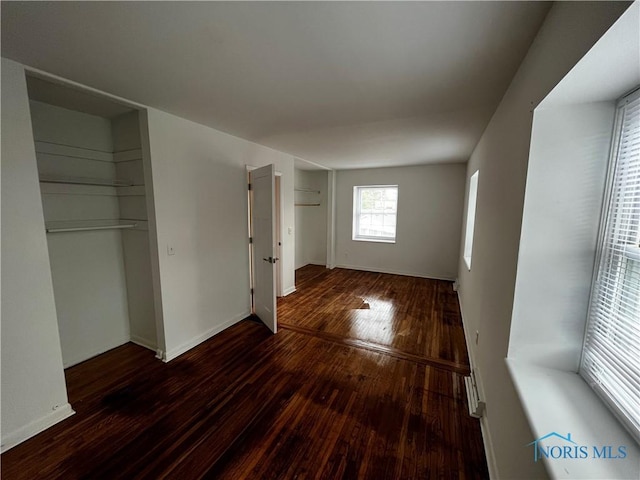 unfurnished bedroom with dark hardwood / wood-style flooring and a closet