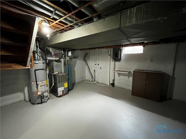 basement featuring heating unit, electric panel, and water heater