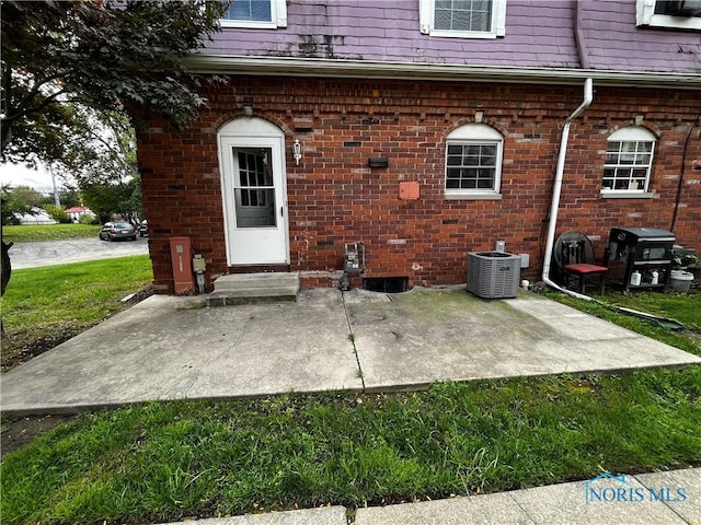 exterior space with a yard, a patio area, and central air condition unit