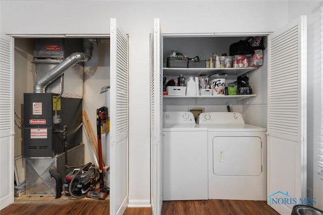 laundry room with washing machine and clothes dryer and dark hardwood / wood-style flooring