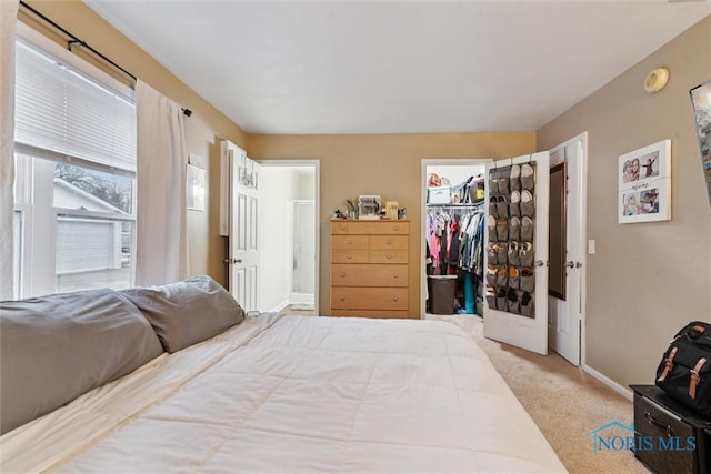 bedroom featuring connected bathroom, a spacious closet, a closet, and carpet flooring