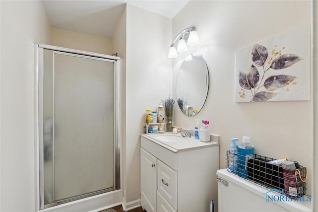 bathroom with vanity, a shower with shower door, and toilet