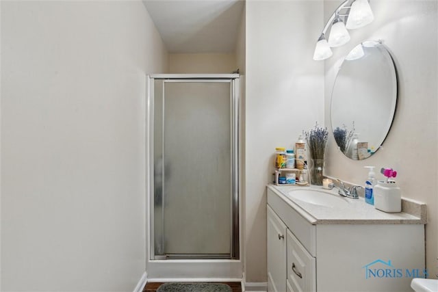 bathroom featuring vanity and a shower with door