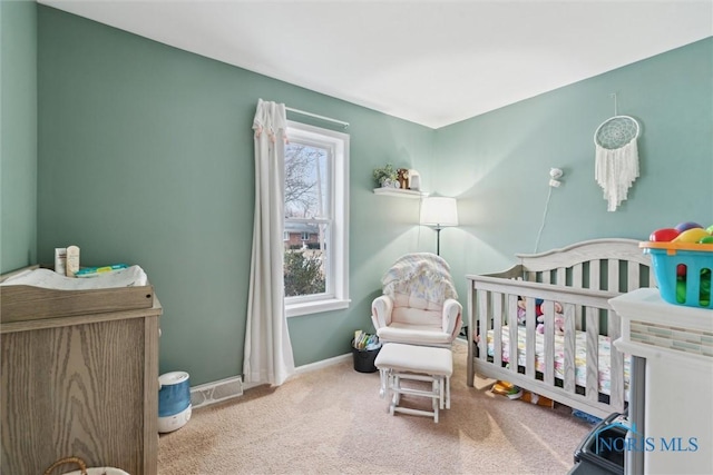 bedroom with a nursery area and carpet