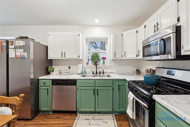 kitchen with dark wood-type flooring, stainless steel appliances, sink, and white cabinets