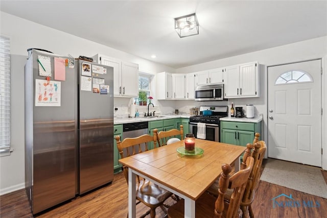 kitchen featuring sink, white cabinetry, appliances with stainless steel finishes, green cabinets, and hardwood / wood-style flooring