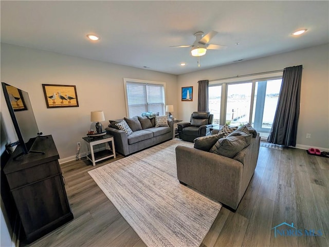 living room featuring dark hardwood / wood-style flooring and ceiling fan