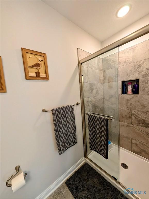 bathroom with tile patterned floors and walk in shower