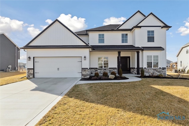 view of front facade featuring an attached garage, stone siding, concrete driveway, board and batten siding, and a front yard