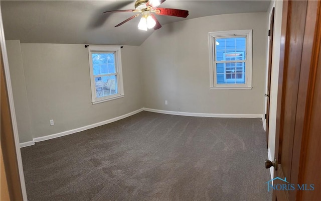 additional living space with ceiling fan, lofted ceiling, and dark colored carpet