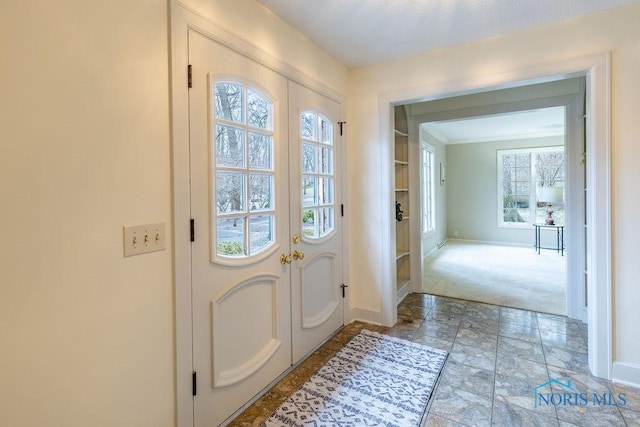 doorway to outside featuring ornamental molding and carpet floors