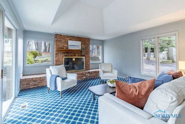 living room with crown molding, carpet floors, a brick fireplace, and a wealth of natural light