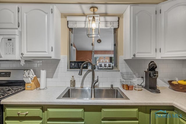 kitchen featuring white cabinetry, sink, and decorative light fixtures