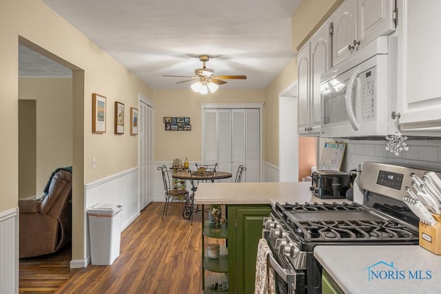 kitchen with green cabinetry, stainless steel range with gas cooktop, dark hardwood / wood-style flooring, ceiling fan, and white cabinets