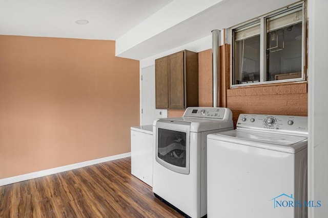 laundry area with dark hardwood / wood-style floors and washing machine and clothes dryer