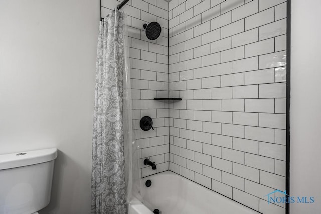 bathroom featuring shower / bath combo and toilet